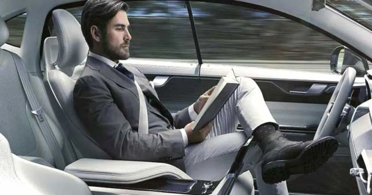A Man Reading A Book While Riding An Autonomous Vehicle