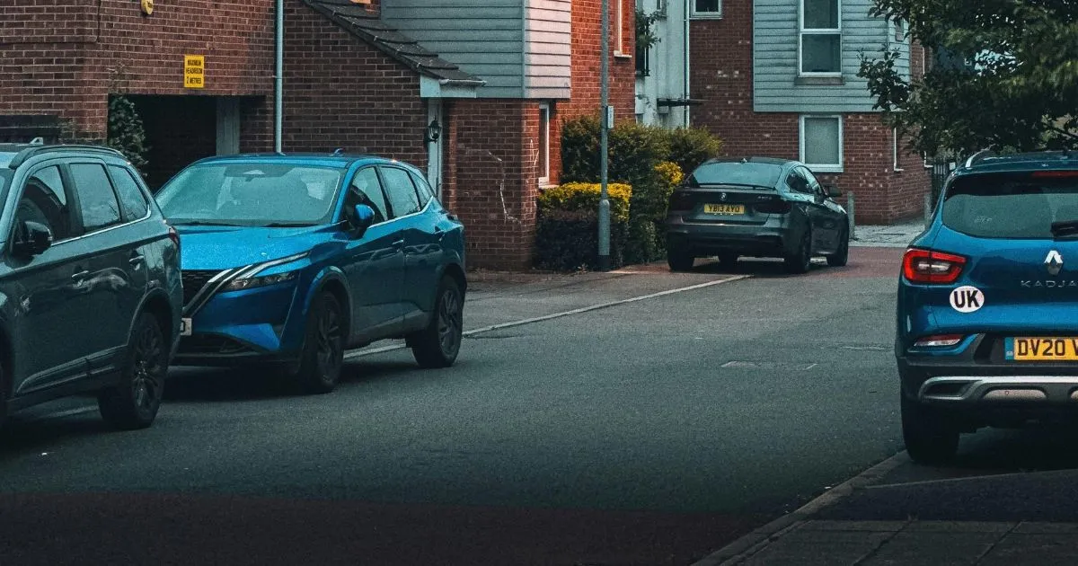 A View Of Cars Parked In Front Of Houses In A Residential Area